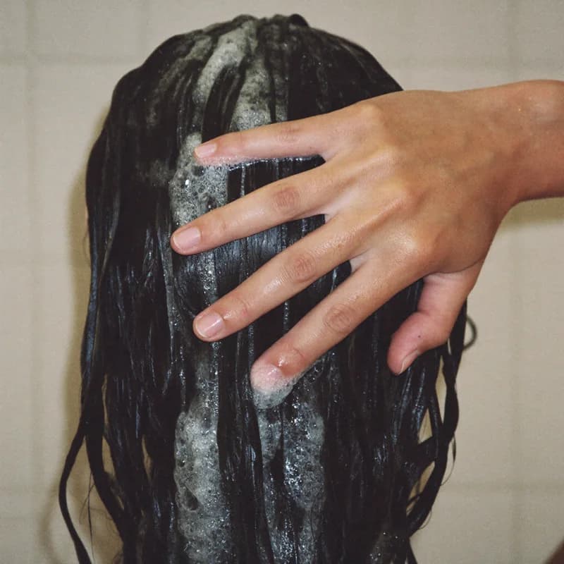 Mousse de shampoing massée sur le cuir chevelu, cheveux mouillés